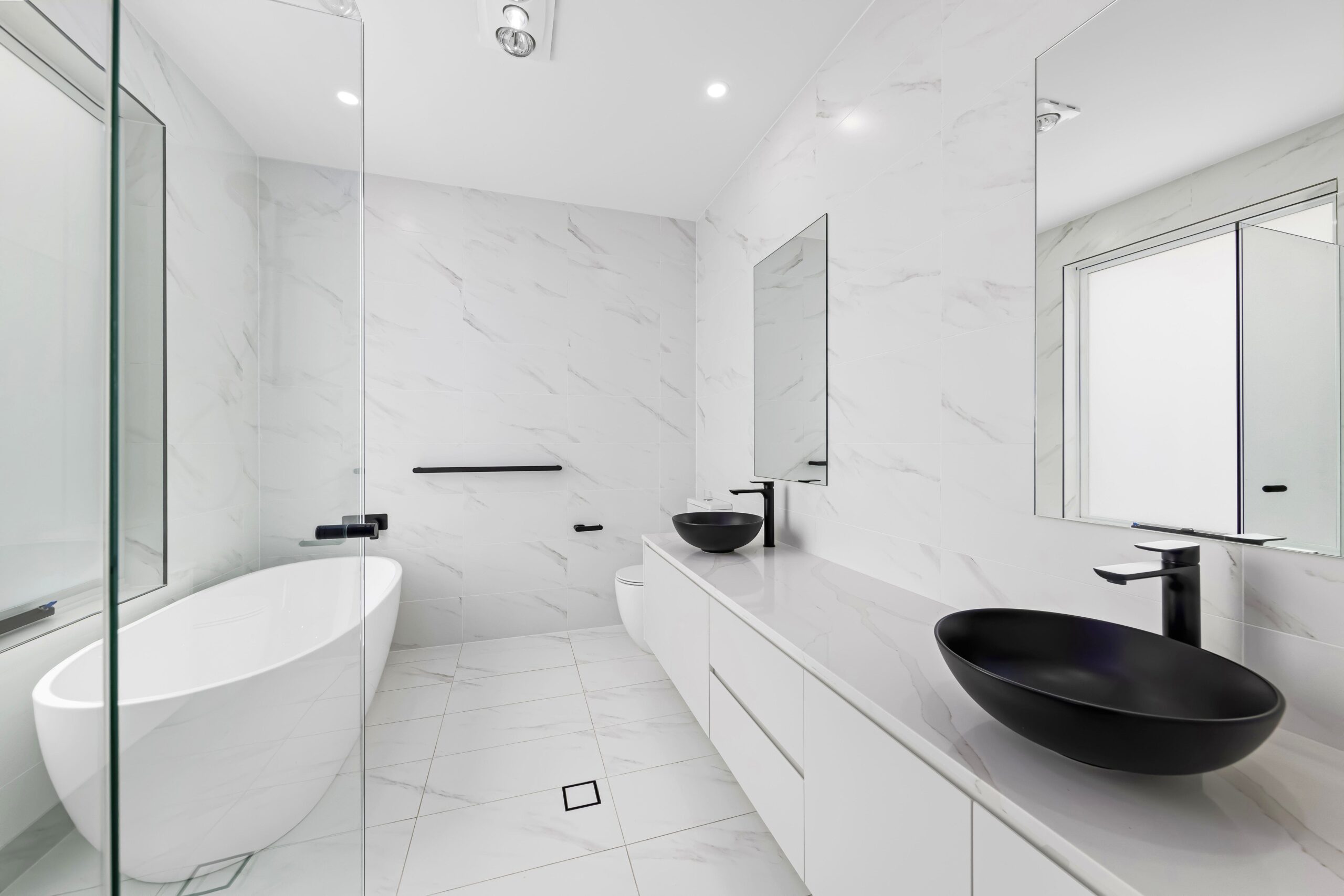 Stylish white bathroom with a bathtub and black sink