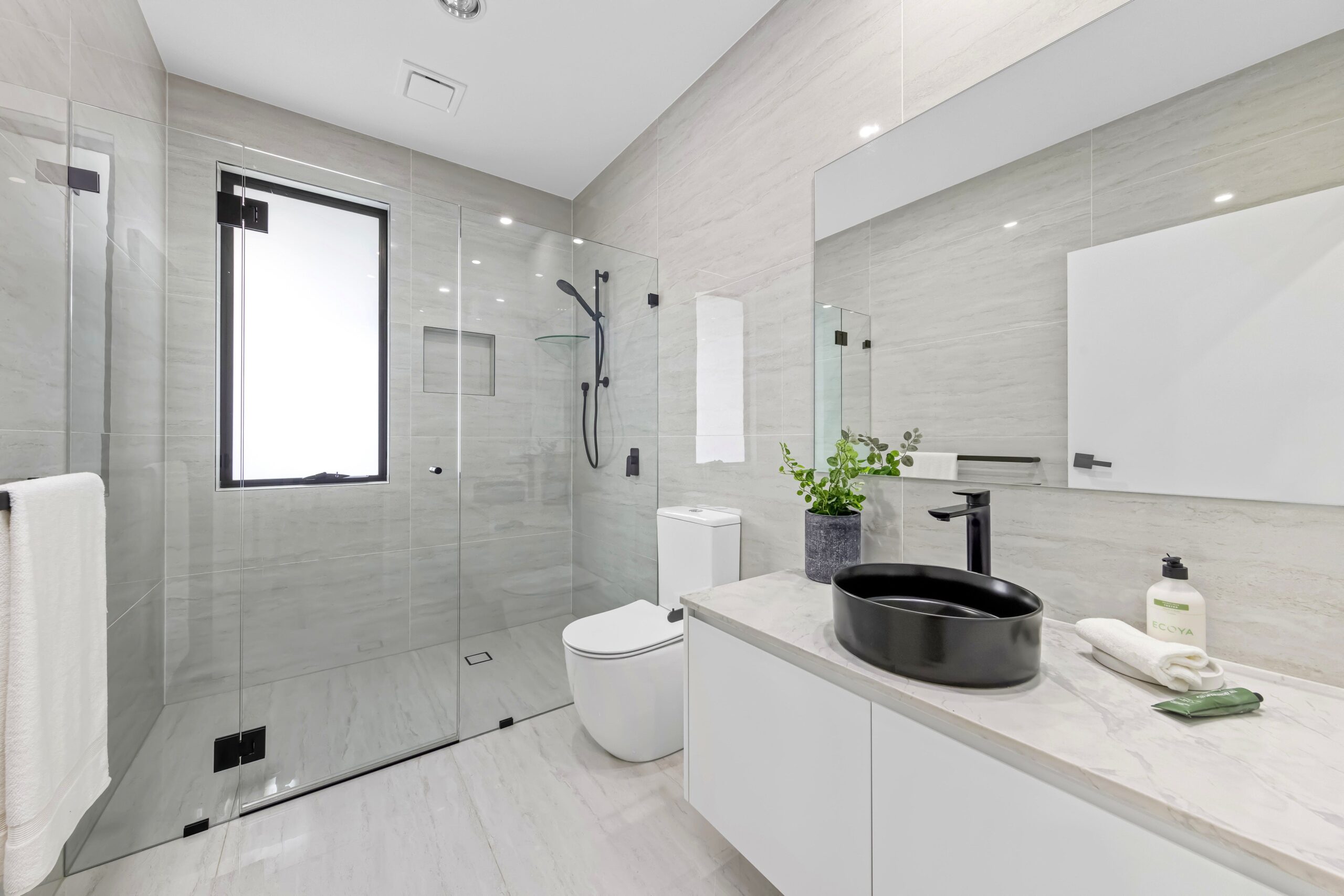 Bathroom with black sink, toilet and glass shower screen