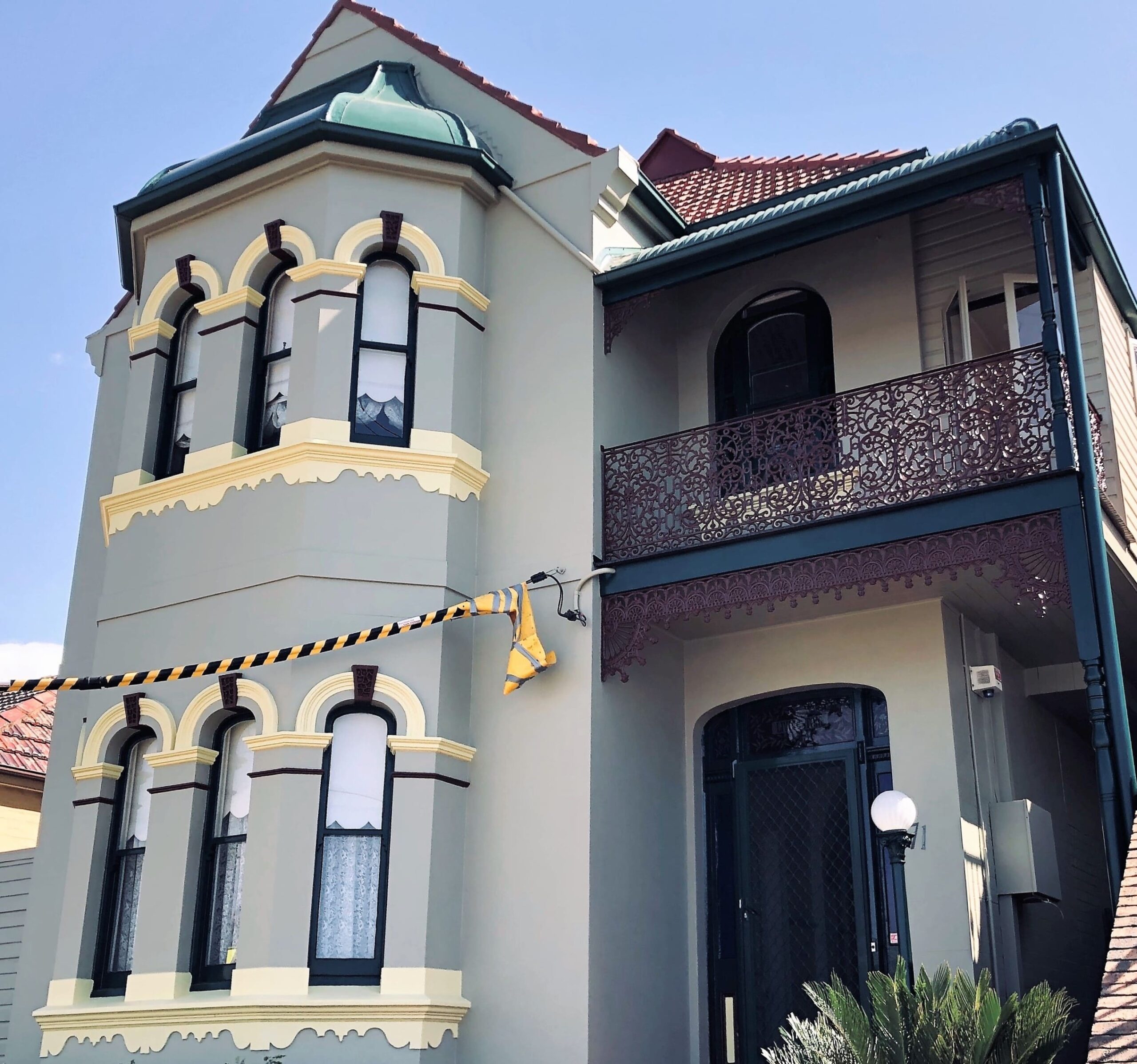 A white house with a balcony and roof on its top