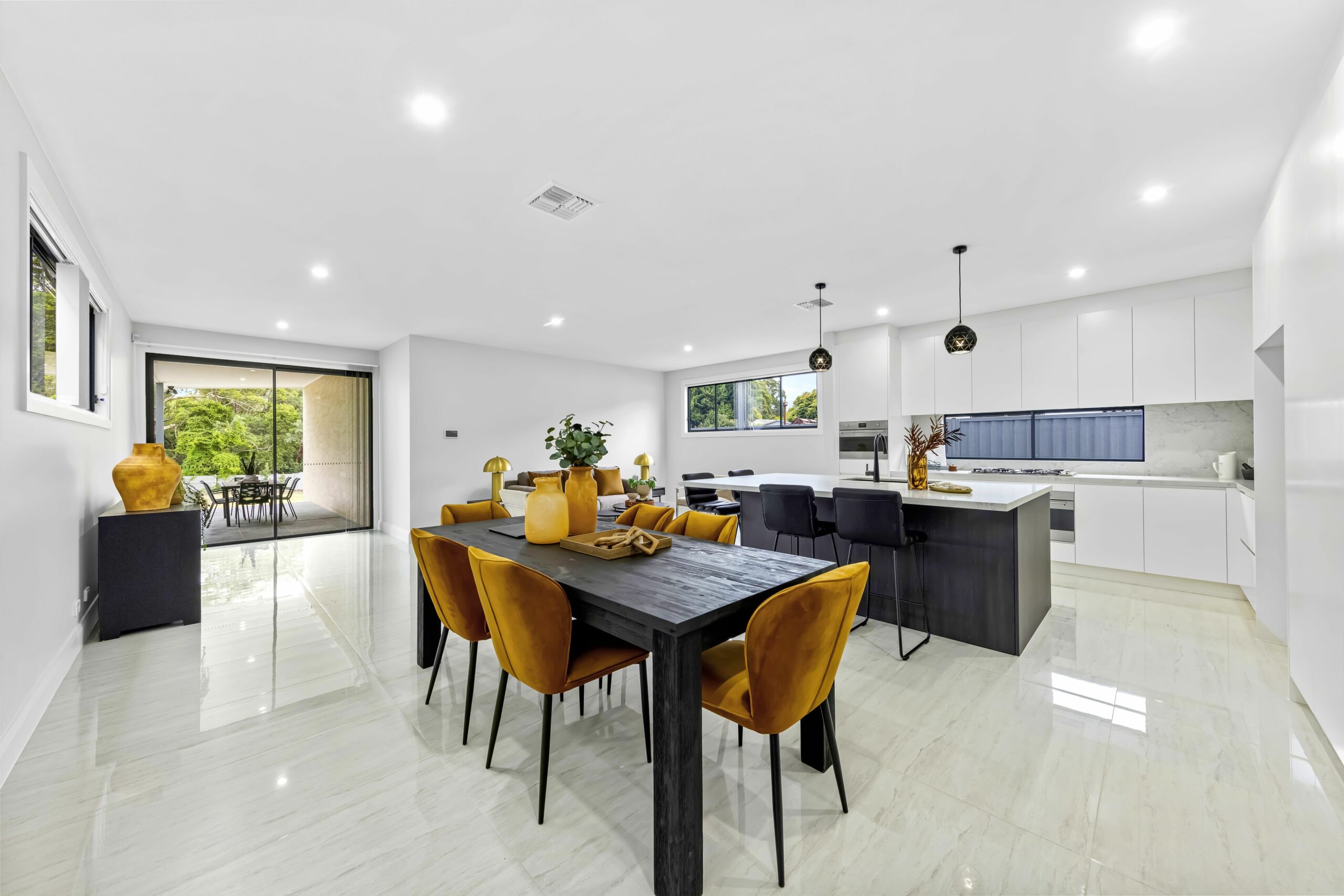 Large kitchen area with dining table and yellow chairs